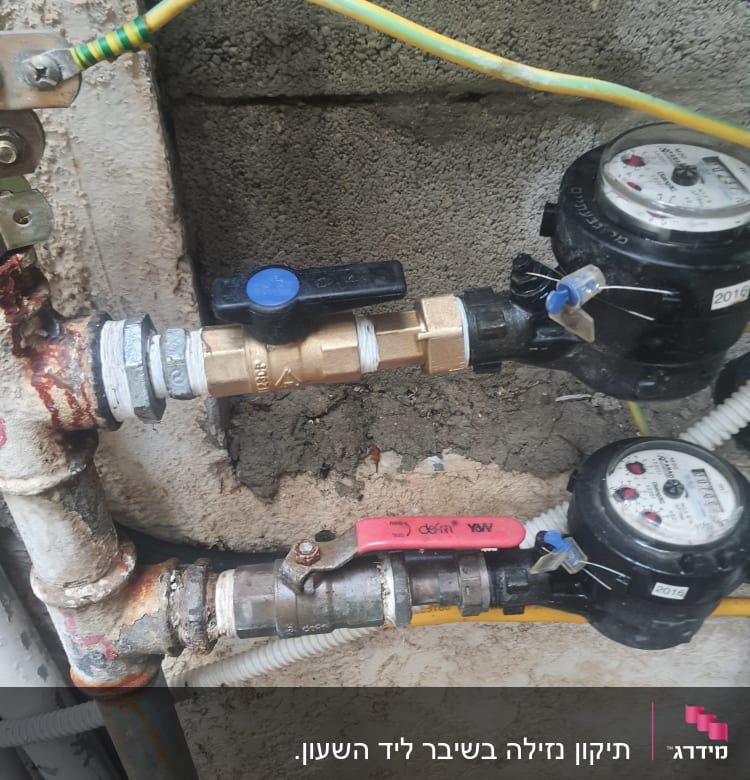 שני מדי מים עם ברזים וצינורות מחוברים לקיר